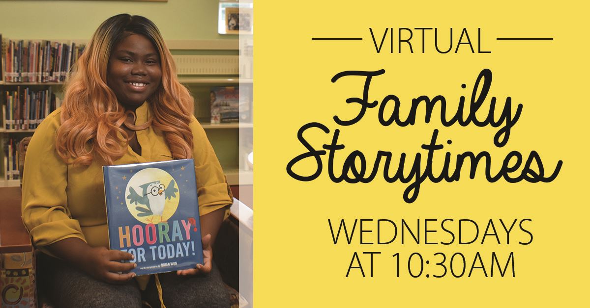 Library staff holding book in kids area of library