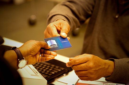 Staff handing back a library card to a patron