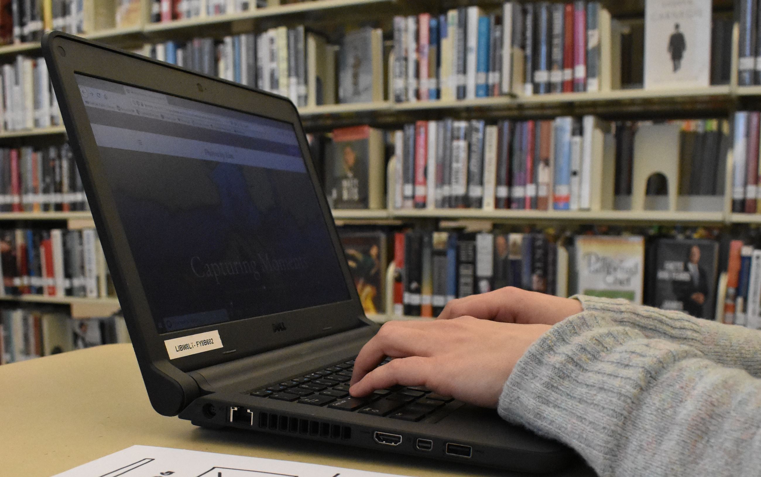 Hands typing on laptop