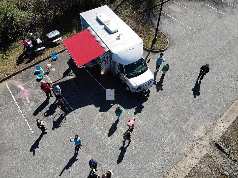 Aerial view of Library2Go vehicle in parking lot surrounded by people